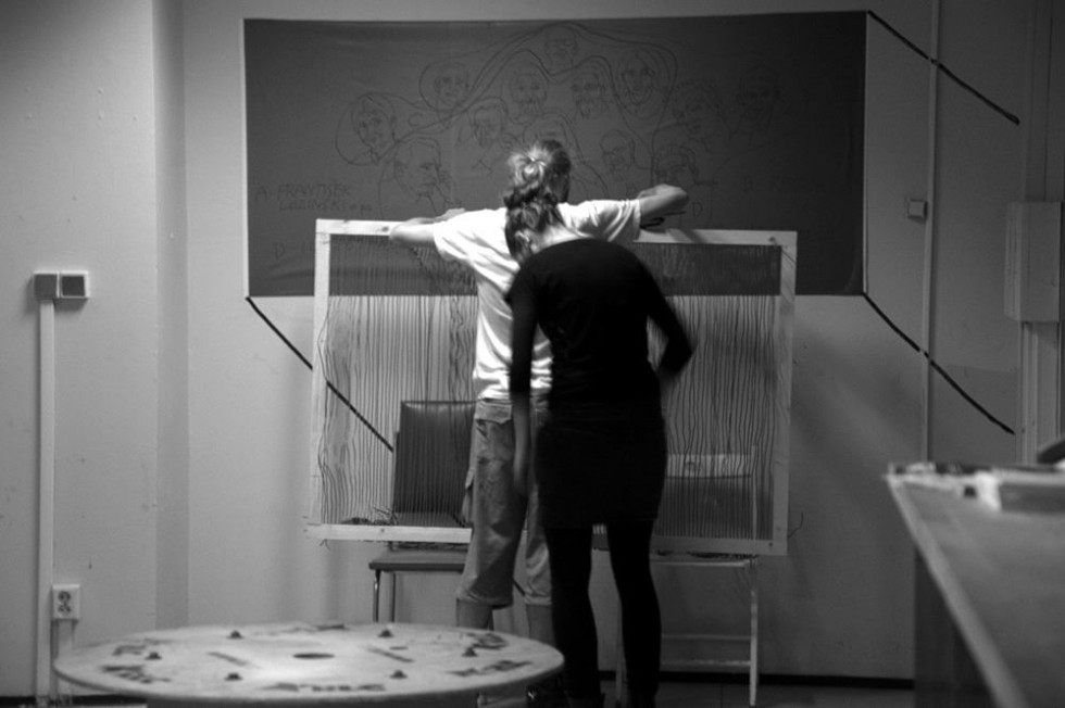 Black and white: two people stringing the wire frame during the build.